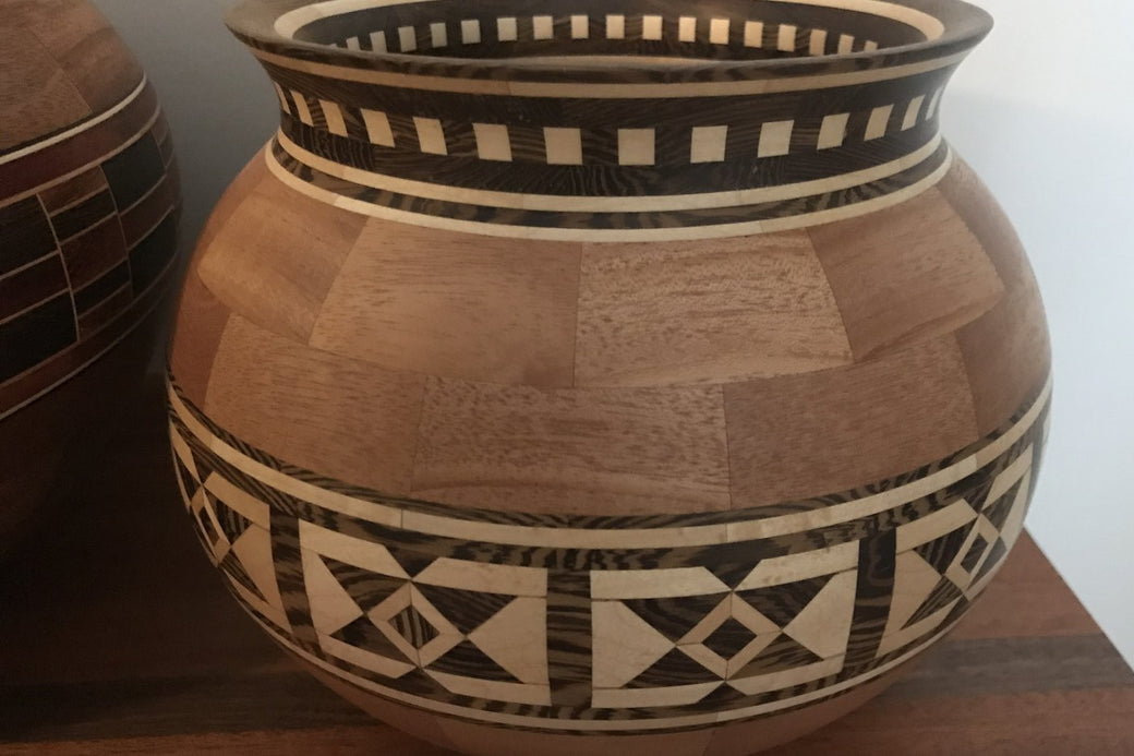 Tall segmented vessel with a diamond and cross feature ring in dark and light woods