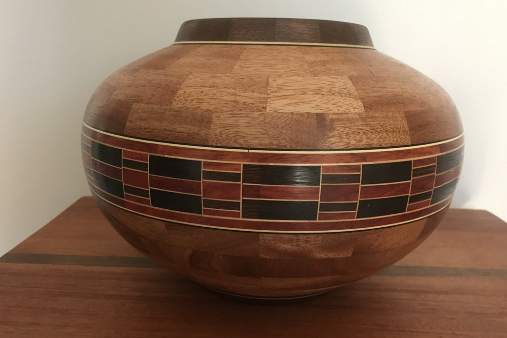 Finished segmented sapele bowl with a brick-work feature ring in red and black
